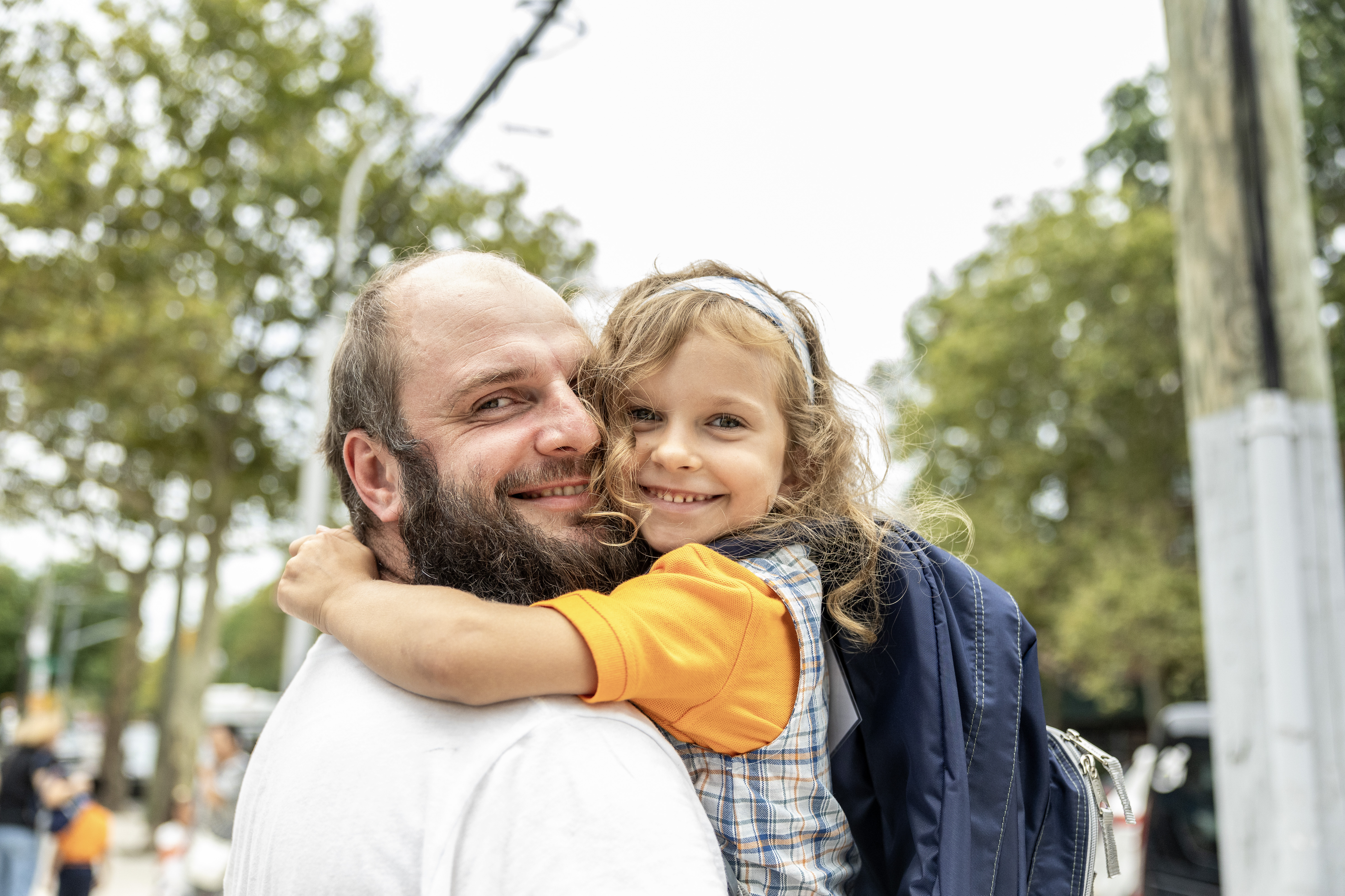 student and father hugging and smiling