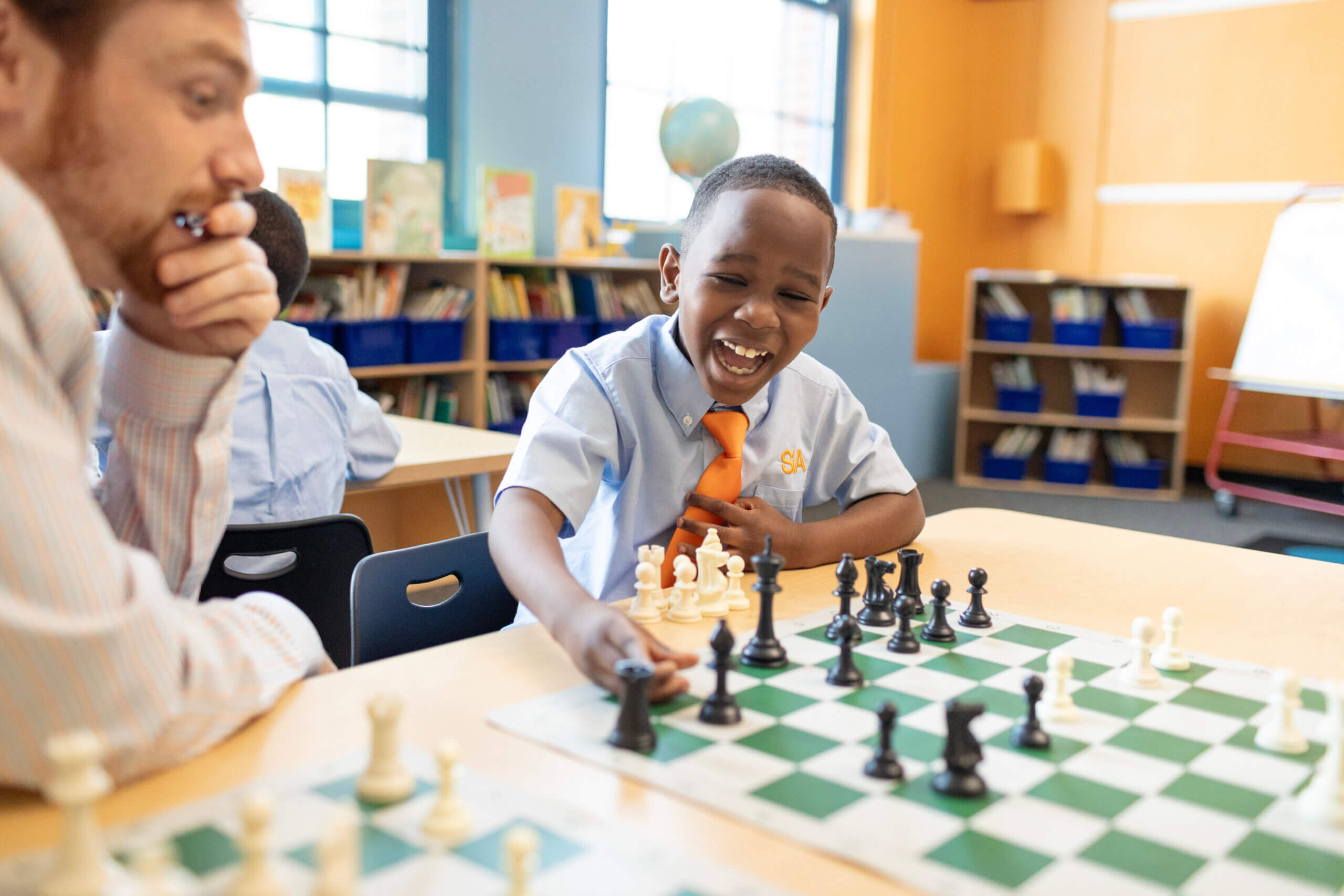 student and teacher playing chess