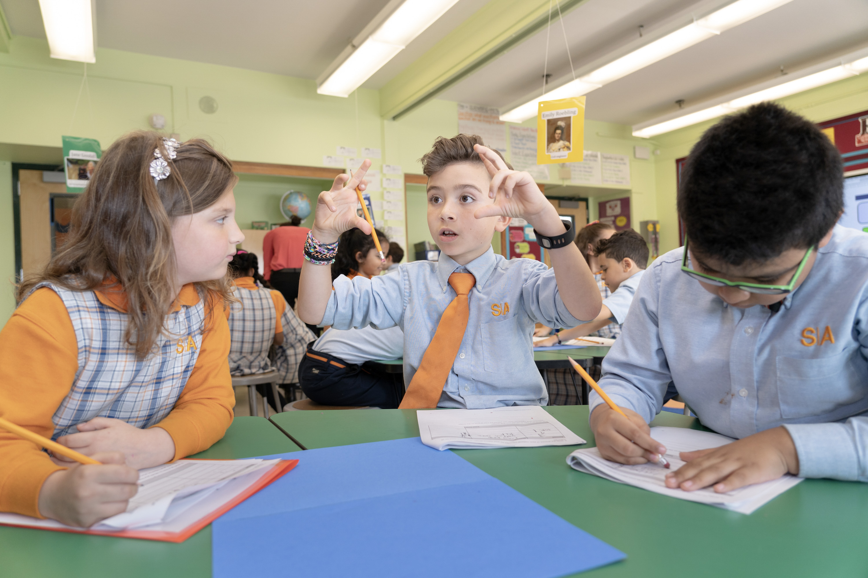 Three students working on a project wearing charter school uniforms