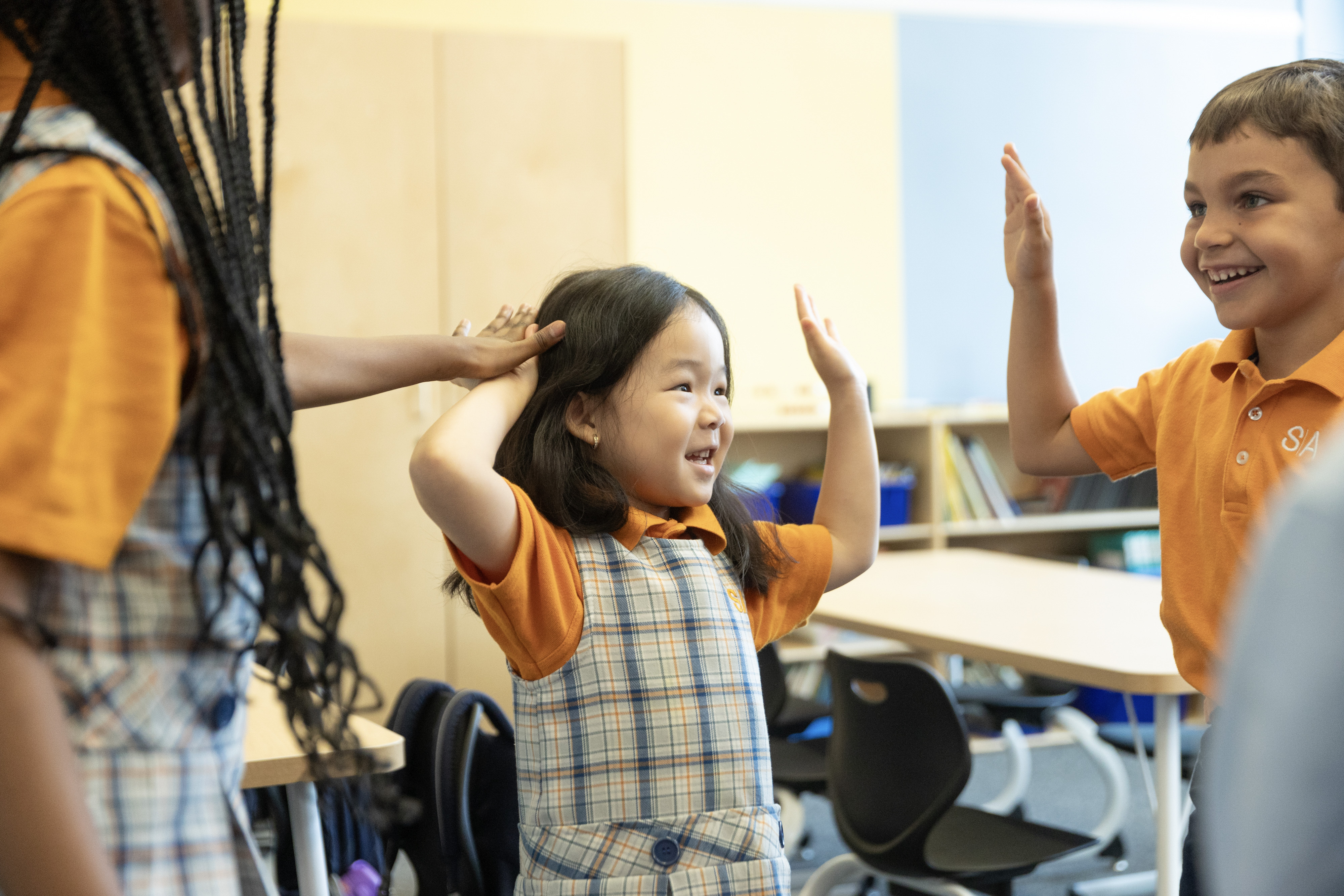 Children standing in a circle high-fiving each other